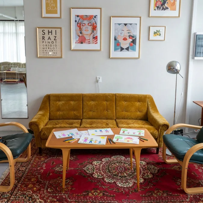 Kirowi Saali lounge-nurk kollase sametdiivani, roheliste tugitoolide, pärsia vaiba ja raamitud pop-artiga peoruumis